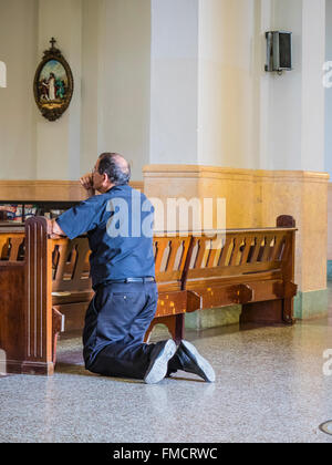 Kubanische Mann kniend im Gebet in einer Kirche in Santiago De Cuba. Stockfoto