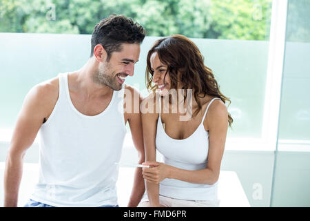 Frau mit Schwangerschaft-Kit neben Mann sitzend Stockfoto