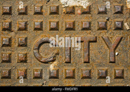 Kanaldeckel mit dem Wort Stadt in Metall Stockfoto