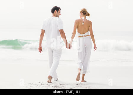 Rückansicht des Paares zu Fuß am Strand Stockfoto
