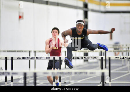 Ein High-flying Runner auf dem Weg zum Sieg in der Hitze des 55 Meter Hürden bei einem indoor High School treffen. USA. Stockfoto