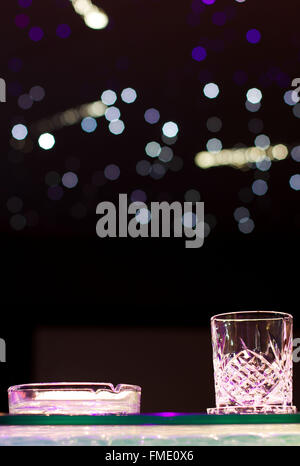 Glas Whisky und Aschenbecher auf der Theke Stockfoto