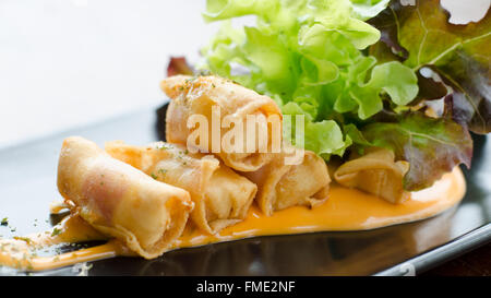 Tiefen Bratwurst in Speck gerollt mit Salat und Chili-Sauce serviert Stockfoto