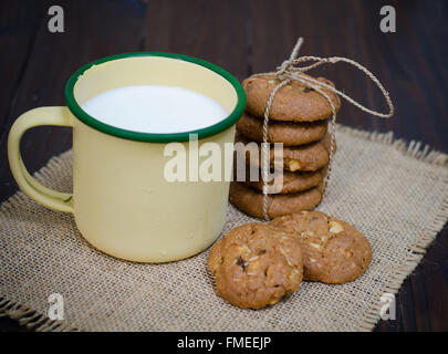 Kekse und Milch auf einem alten hölzernen Hintergrund Stockfoto
