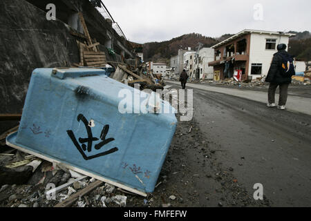 Kamaishi, Iwate Präfektur, Japan. 25. März 2011. Native Überlebenden verlassen ihr Haus auf Schutt und Schlamm bedeckt am Tsunami traf zerstörte Mine Stadt in Kamaishi am 25. März 2011, Japan. Am 11. März 2011 erschütterte ein Erdbeben mit einer Magnitude von 9.0, der größte in der aufgezeichneten Geschichte der Nation und einer der mächtigsten jemals aufgenommen, auf der ganzen Welt fünf Japan. Innerhalb einer Stunde nach dem Erdbeben wurden Städte, die das Ufer gesäumt von einem gewaltigen Tsunami, verursacht durch die Energie, die durch das Erdbeben abgeflacht. Mit Wellen von bis zu vier oder fünf Meter hoch stürzte sie durch Zivilisten Häuser, Stockfoto