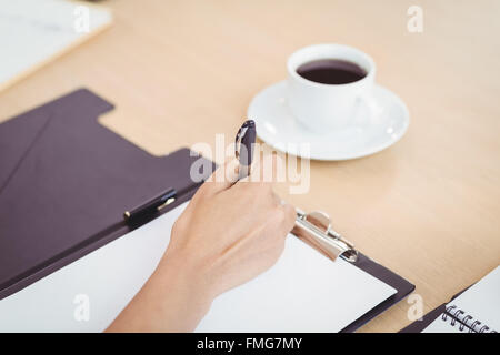 Nahaufnahme von Ärztinnen Handschrift in Zwischenablage Stockfoto