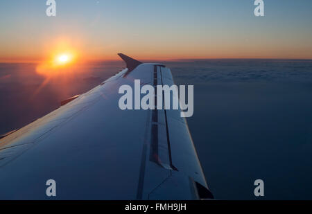 Sonnenuntergang über Flugzeugflügel aus Flugzeug im Flug Stockfoto