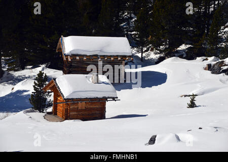 Zwei traditionelle Almhütte im Schnee gefüllt Wiese in Corvara Dolomiten Stockfoto