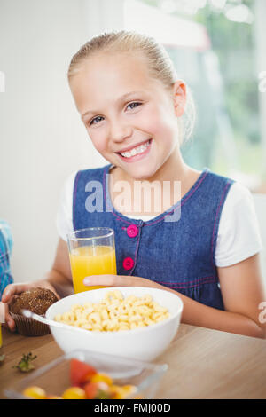 Glückliches Mädchen frühstücken vom Tisch Stockfoto