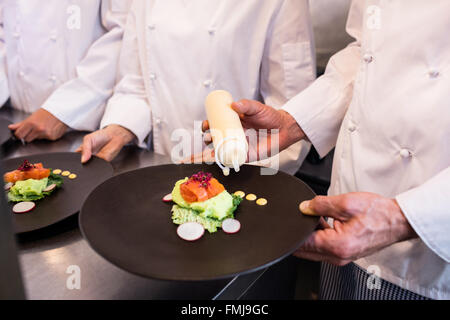 Koch Dekorieren ein Essen Platte Stockfoto