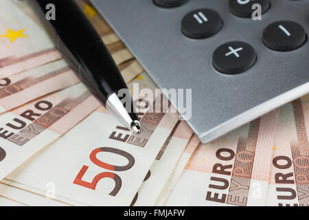 Rechner und einen Stift auf den Euro als Hintergrund liegend Stockfoto