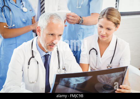Zwei Ärzte untersuchen einen Röntgen-Bericht Stockfoto