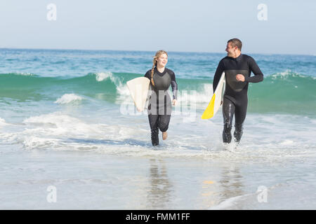Paar mit Surfbrett am Strand Stockfoto