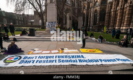 London, UK. 12. März 2016. Banner auf einer Kundgebung statt außerhalb der Houses of Parliament in Westminster, den fünften Jahrestag der Atomkatastrophe von Fukushima in Japan zu erkennen und zum protest gegen die japanische Regierung Pläne, das Kernkraftwerk Sendai neu zu starten. Bildnachweis: Stephen Chung/Alamy Live-Nachrichten Stockfoto