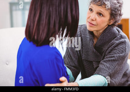 Mutter im Gespräch mit Tochter auf sofa Stockfoto