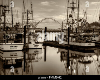 Yaquina Brücke am Newport Hafen mit Fischerbooten und Sonnenuntergang. Newport, Oregon Stockfoto