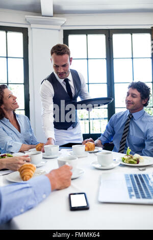 Kellner serviert Kaffee für Geschäftsleute Stockfoto