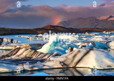 Regenbogen über Eisberge in der Gletscherlagune Jökulsárlón, Jökulsárlón, in der Nähe von Hofn Süden Islands Stockfoto