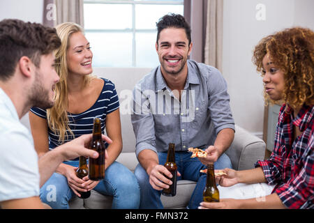 Junge Freunde, Bier und Pizza zu Hause auf sofa Stockfoto