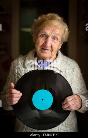 Eine ältere Frau mit der Vinyl-Platte in seinen Händen. Stockfoto