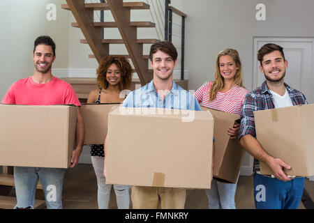 Freunde Lächeln während des Tragens Kartons Stockfoto