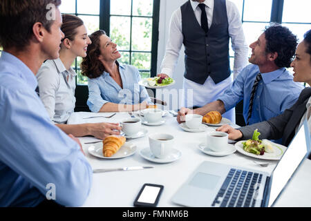 Kellner servieren Salat für Geschäftsleute Stockfoto