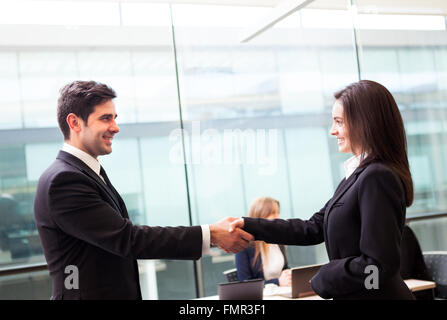 Business Handshake im modernen Büro mit Bussiness Menschen auf Hintergrund Stockfoto