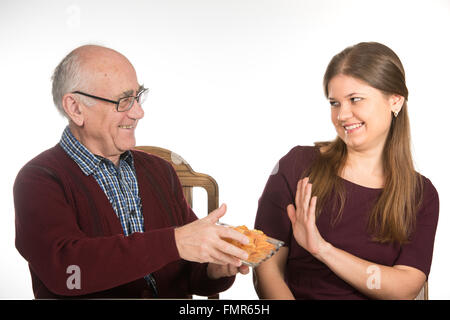 alten senior Mann und junge Frau Essen Kartoffelchips Stockfoto