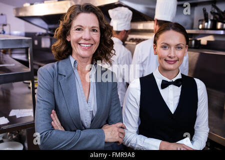 Restaurantleiter und Kellnerin lächelnd in Großküchen Stockfoto