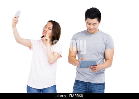 Junge Frau, die eine Selfie auf Smartphone und Mann mit digital-Tablette Stockfoto