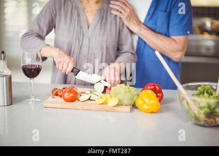 Mittelteil der ältere Mann mit Frau schneiden Salat Stockfoto