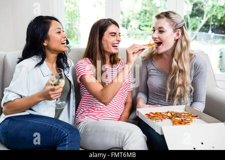 Schöne junge Freundinnen genießen Sie Wein und pizza Stockfoto