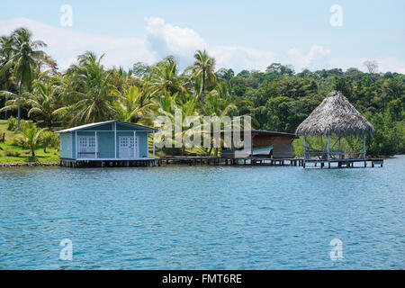 Tropische Küste mit kleinen Häuschen und strohgedeckte Hütte über dem Wasser in Bocas del Toro, karibische Küste von Panama in Mittelamerika Stockfoto