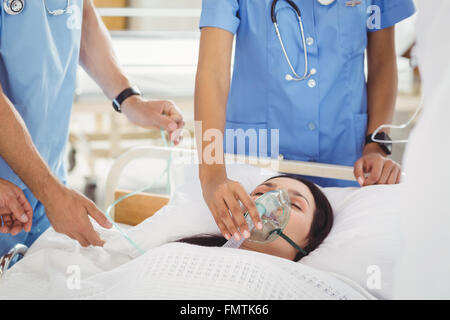 Ärzte, die Patienten eine Sauerstoffmaske aufsetzen Stockfoto