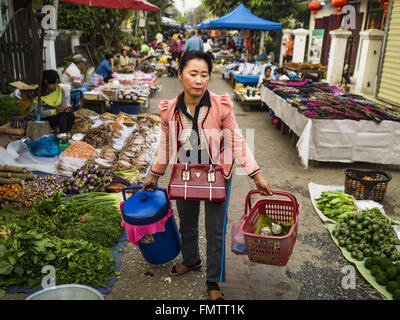 Luang Prabang, Luang Prabang, Laos. 13. März 2016. Eine Frau geht durch den Markt in Luang Prabang. Luang Prabang wurde 1995 zum UNESCO-Weltkulturerbe ernannt. Der Umzug gespeichert koloniale Architektur der Stadt, aber die Explosion des Massentourismus hat ein Tribut an die Seele der Stadt. Laut einer aktuellen Studie geht jetzt ein kleines Grundstück, das für $8.000 vor drei Jahren verkauft für $120.000. Viele langjährige Bewohner sind Verkauf ihrer Häuser und Umzug in kleine Entwicklungen rund um die Stadt. Die alten Häuser sind dann in Thermen, Pensionen und Restaurants umgewandelt. Die Stadt ist berühmt für die mo Stockfoto