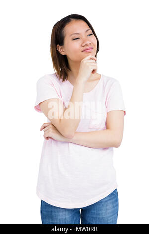 Nachdenkliche junge Frau stehend mit Hand am Kinn Stockfoto