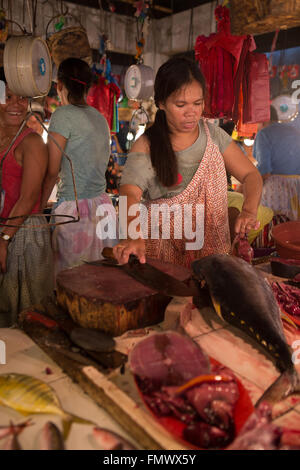 Eine Frau, die einen frischen Thunfisch, im Markt Talisay, Cebu City, Philippinen gut vorbereiten Stockfoto