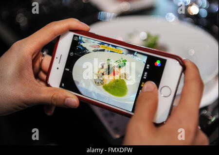 Los Angeles, USA. 12. März 2016. Ein Teilnehmer nimmt Fotos von Speisen als fünf Spitzenköche in der asiatischen Küche vorhanden statt einer gemischt-Stil Abendessen in der Ost-West-Masters-Dinner Nacht während der All-Star-Chef Classic Los Angeles in Los Angeles, USA, am 12. März 2016. © Zhang Chaoqun/Xinhua/Alamy Live-Nachrichten Stockfoto