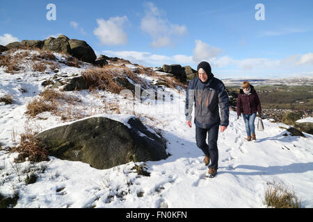 Wanderer machen ihren Weg auf einem verschneiten Ilkley Moor nach starkem Schneefall. Stockfoto