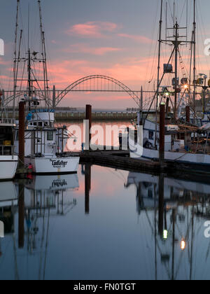 Yaquina Brücke am Newport Hafen mit Fischerbooten und Sonnenuntergang. Newport, Oregon Stockfoto