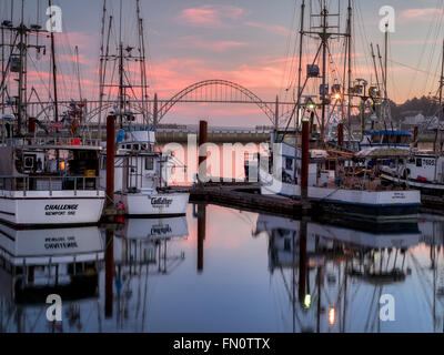 Yaquina Brücke am Newport Hafen mit Fischerbooten und Sonnenuntergang. Newport, Oregon Stockfoto