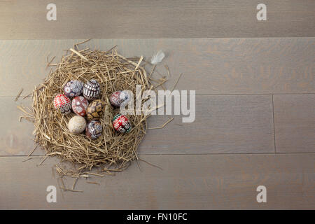 Ostereier im Nest auf hölzernen Hintergrund Stockfoto
