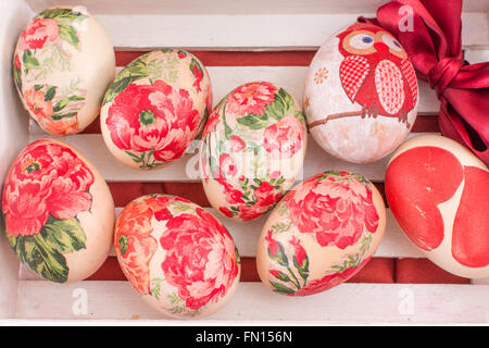 Hand bemalt und Serviettentechnik verziert Ostereier in einer Holzkiste Stockfoto