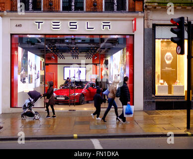 Menschen auf der Oxford Street an einem Abend Anfang März 2016 gehen vorbei an den Tesla-Autohaus. Stockfoto