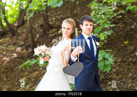Braut und Bräutigam mit einem Schild in Herzform. Stockfoto
