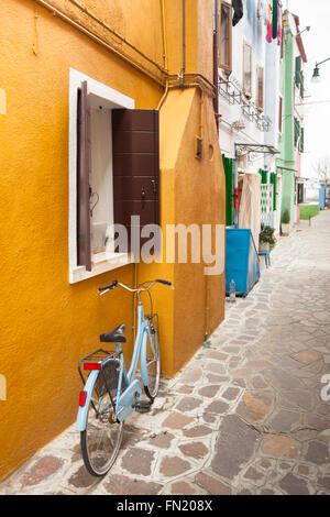 altes Fahrrad geparkt lange eine Außenwand in Insel Burano, Venedig Stockfoto