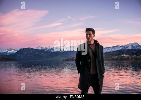 Hübscher junger Mann auf Luzern See an einem sonnigen, ruhigen Tag, stehend. Landschaft der Schweiz Stockfoto