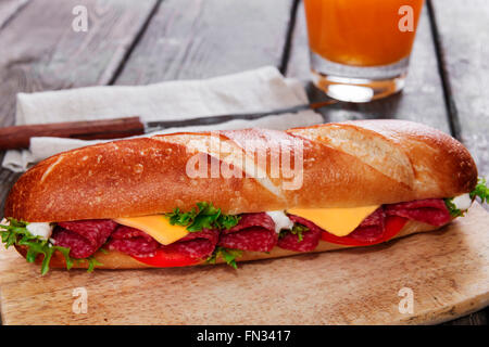 Sandwich-Baguette-Käse-Salami-Tomaten-Sauce und Kräuter Stockfoto