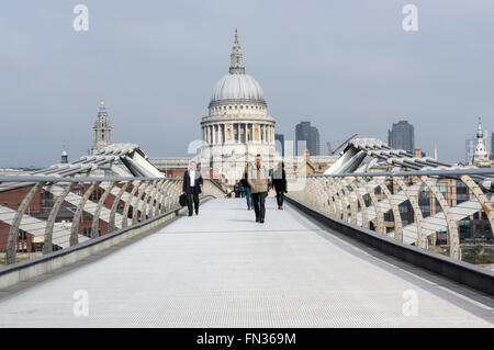 Menschen über die Millennium Brücke über die Themse mit der Kuppel der St. Pauls Kathedrale im Hintergrund. Stockfoto