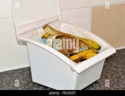 Küche Speisereste in einer Lidern sammeln Box mit Papier, Teebeutel und Banana Skins für recycling im Hause Kompost. Stockfoto